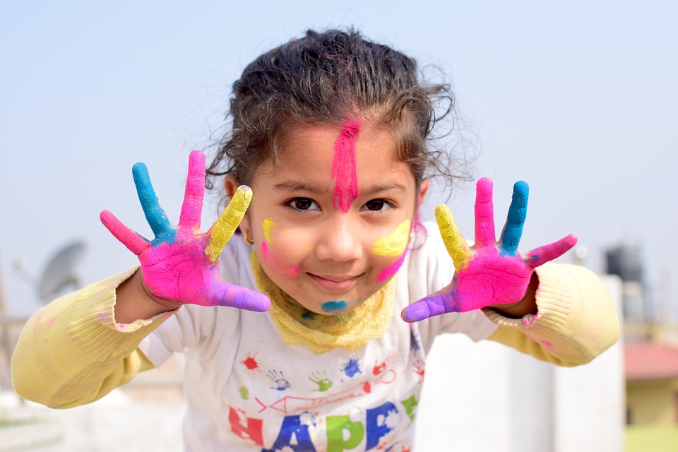 Little girl with paint on her hands and face