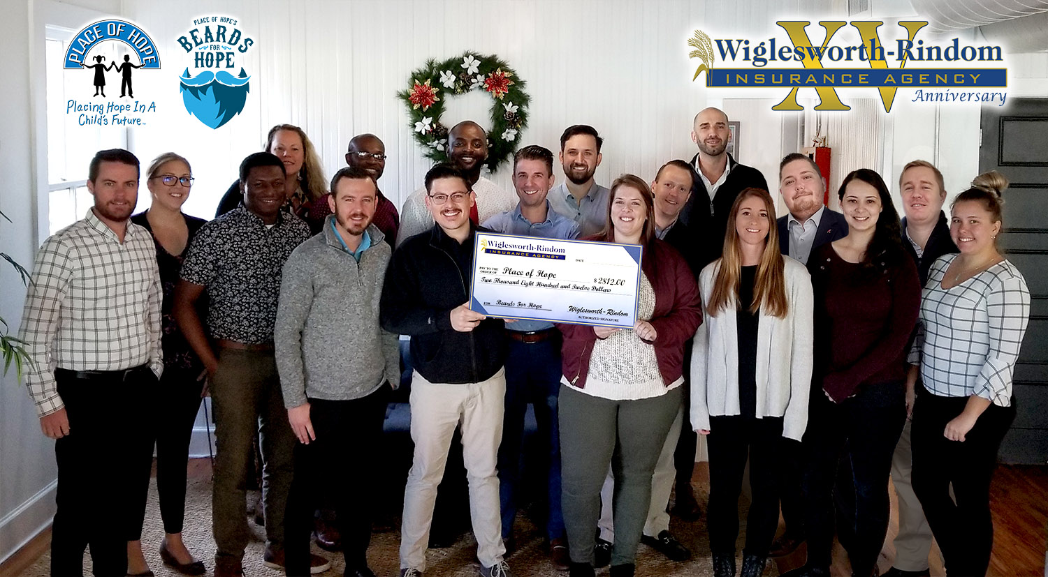 All 20 Insurance Agents holding a giant check for the grand total of the charity donation