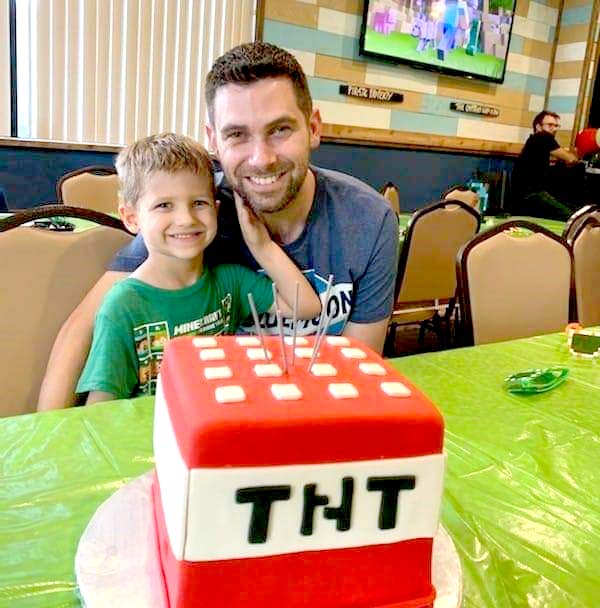 Joshua Padgette and his son posing with a cake