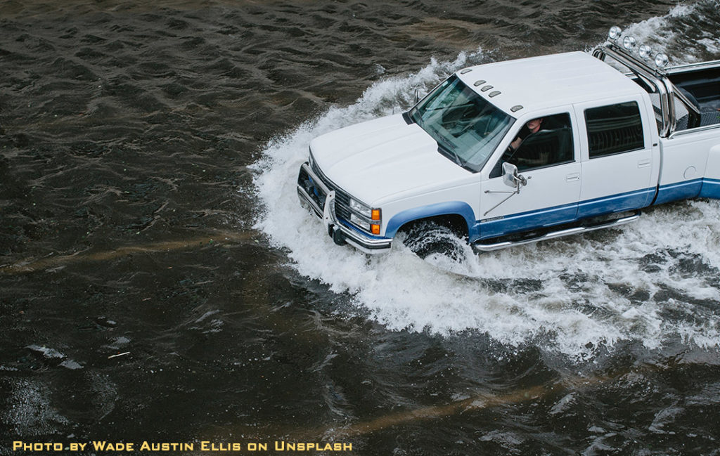 truck driving through flooded street