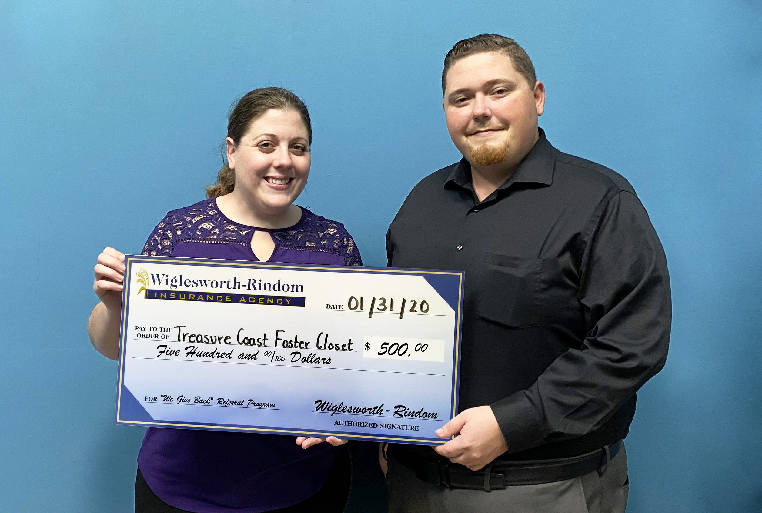 Tara Betancourt posing with a giant check and Insurance Agent Kyle Cocchia