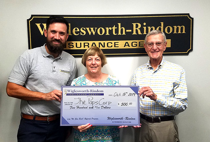 Sue and Bill Mann posing with a giant check with Insurance Agent Lee Wiglesworth